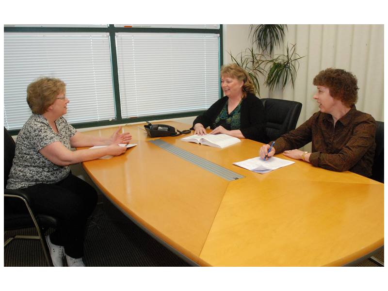 3 people meeting holding a meeting in a conference room